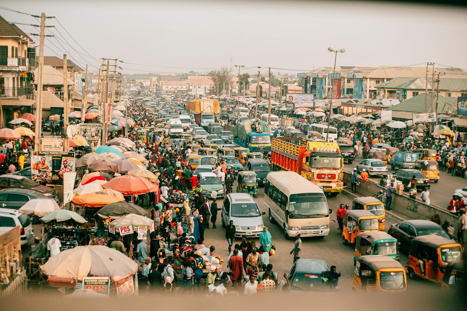 A lively street market with busy traffic in a vibrant city, showcasing daily life.