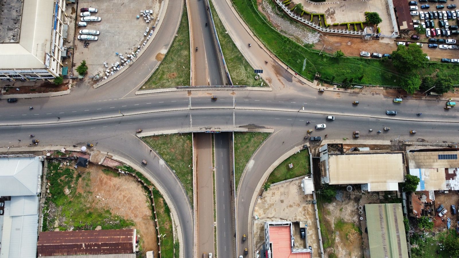 Aerial shot of a city intersection with roads and buildings, showcasing urban planning.