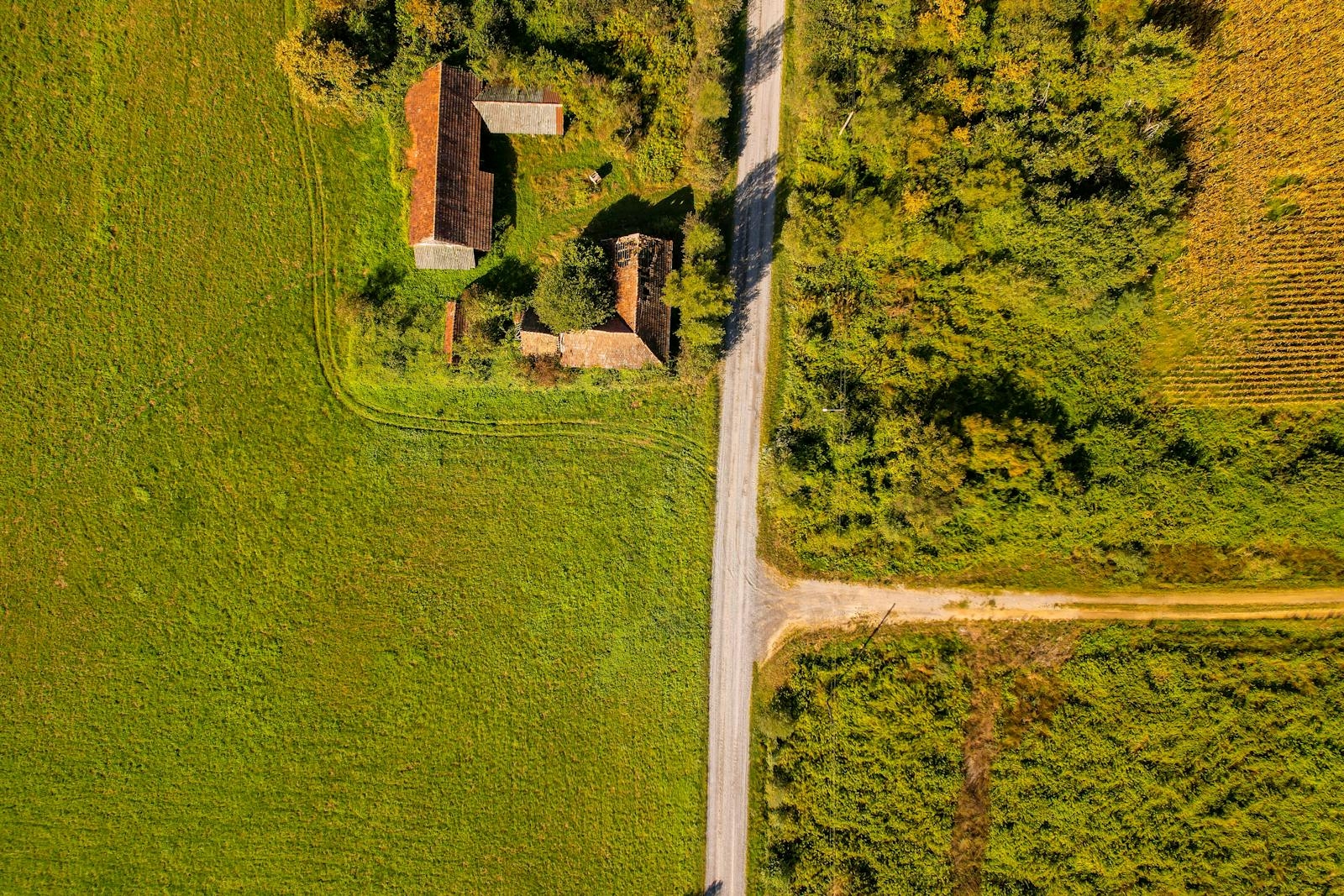 Aerial shot of a rural farmhouse surrounded by fields in Garešnica, Croatia.