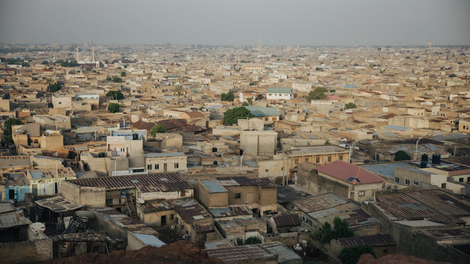 Aerial cityscape of Kano, Nigeria showcasing dense urban architecture and sprawling rooftops.