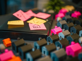 A vibrant display of miniature houses and sticky notes, illustrating real estate planning concepts.