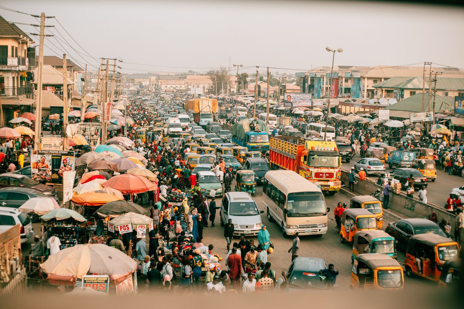 A lively street market with busy traffic in a vibrant city, showcasing daily life.