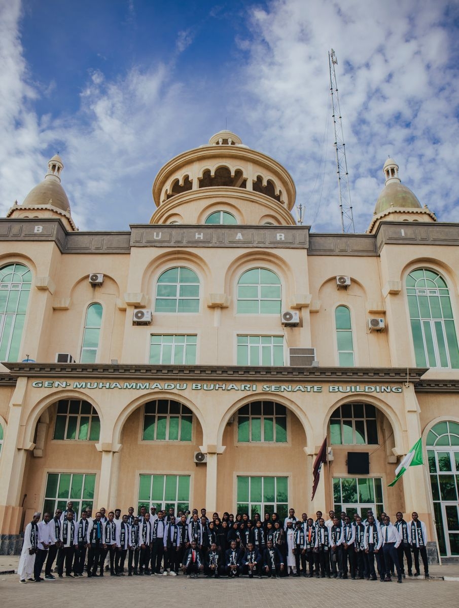 Large group of people posing in front of Gen Buhari Senate Building.