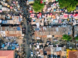 Vibrant aerial photo capturing the lively street market in Kaduna, Nigeria, showcasing colorful umbrellas and crowded streets.