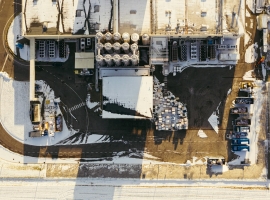 Aerial shot of an industrial plant covered in winter snow in Poland, showcasing infrastructure and storage areas.