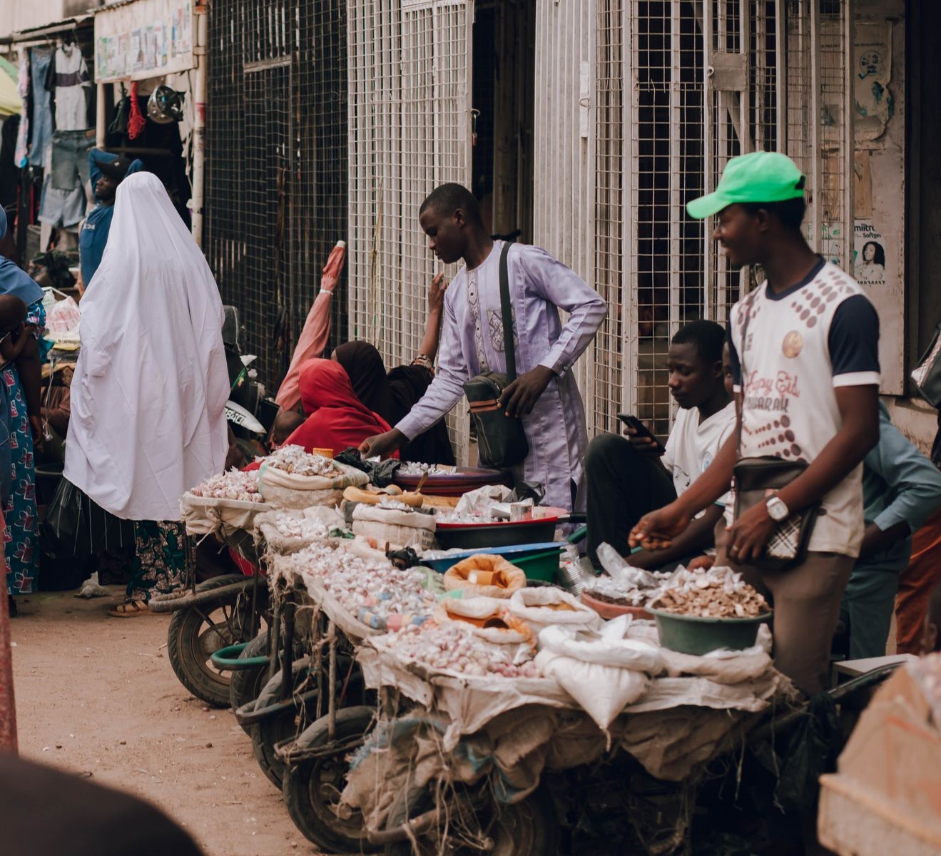 Lively scene of an African street market with vendors and customers interacting.